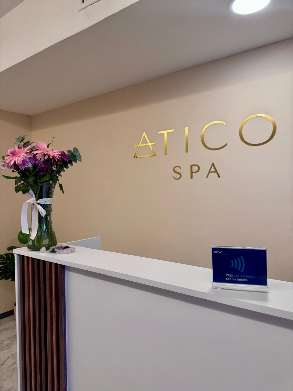 Recepción de Ático Spa con flores y logo dorado